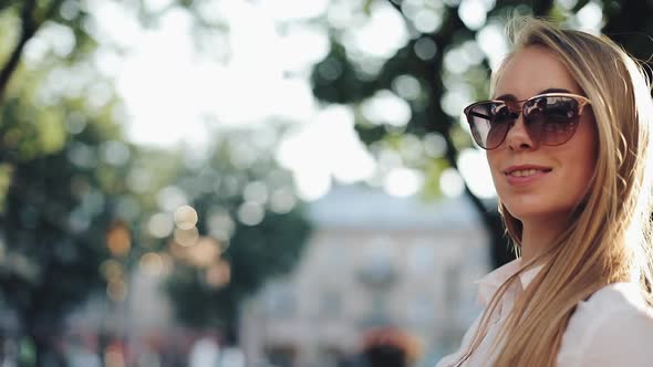 Charming Young Woman with a Magnificent Brown Hair and Stylish Sunglasses. Attractive Young Lady