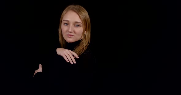 Sensual Blonde Woman Is Wearing Black Dress Is Posing on Black Background in Studio