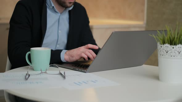 Remote Job. A Man Is Working with Documents on Laptop Remotely at Home. A Business Man Is Using