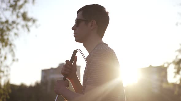 Blind Man with a Cane Sitting on Sunset