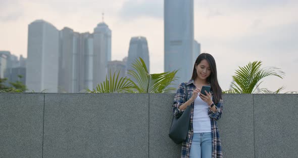 Woman look at mobile phone in city