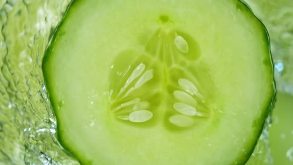 Super Slow Motion Shot of Splashing Water on Rotating Cucumber Slice at 1000Fps