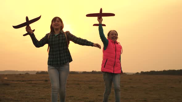 Children Play Toy Airplane. Teenagers Want To Become Pilot and Astronaut. Happy Girls Run with Toy