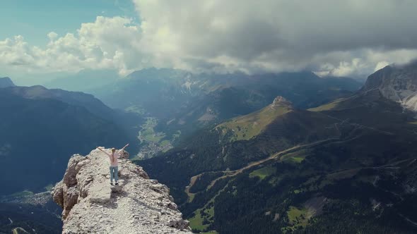 Aerial View of Italian Dolomites with Hands Raised Woman on the Top of Piz Boe Mountain