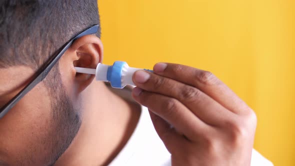 Young Man Cleaning His Ear with Cleaning Equipment