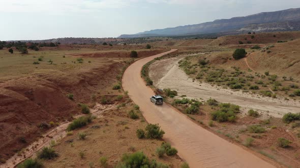 Off-road Vehicle Driving In Dusty Dirt Road In Toquerville, Utah. - aerial