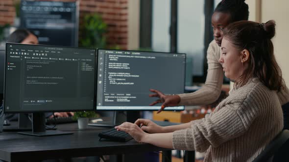 Junior Programer Writing Algorithm Under Experienced Colleague Supervision Sitting at Desk with