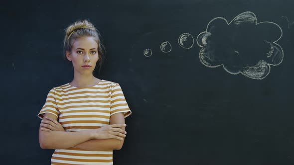 Portrait of woman in front of chalkboard