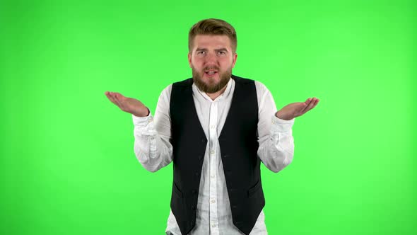 Displeased Man Indignantly Talking To Someone, Looking at the Camera. Green Screen