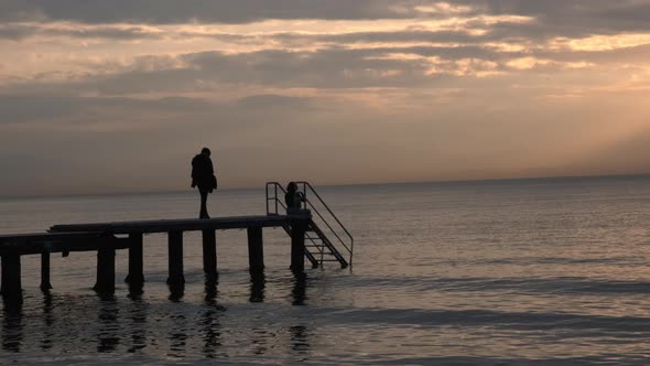 Young People Looking At The Sea And The Sunset