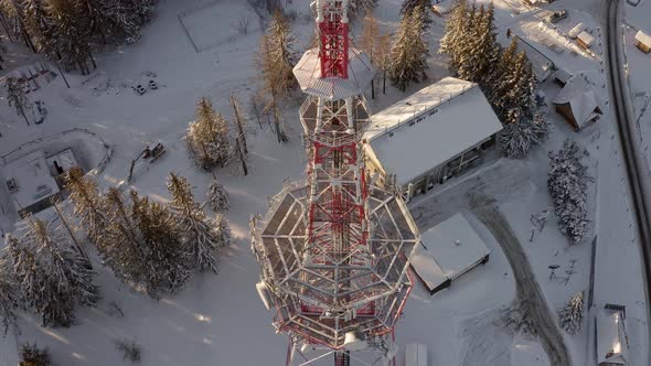 Cell tower in snowy landscape at Gubalówka, Poland. Aerial tilt-up descending reveal