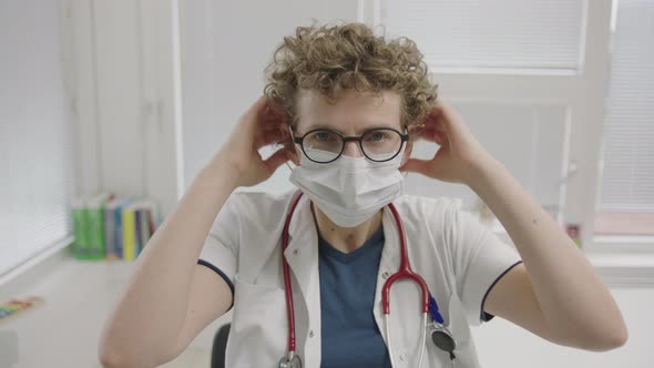 Doctor Putting On Face Mask To Protect Against Coronavirus