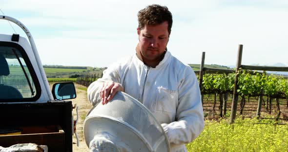 Beekeeper wearing beesuit while preparing for harvest