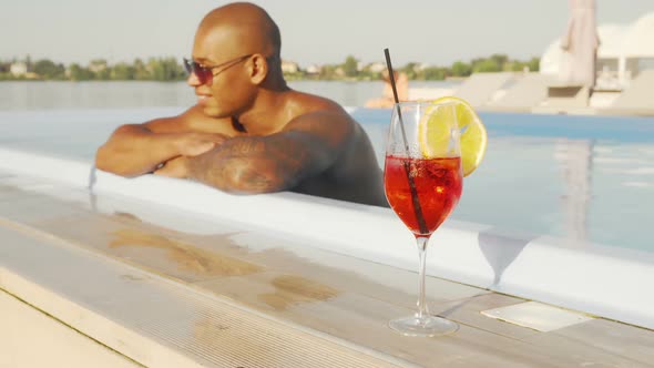 African Young Man Relaxing in the Swimming Pool