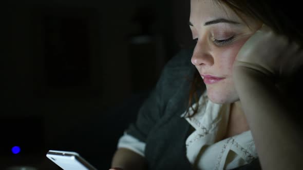 Young beautiful woman indoor at home using smart phone at night