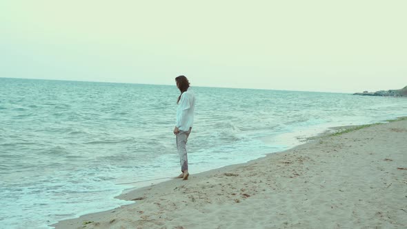 Beautiful Summer Woman Walking in Sea Water with Waves