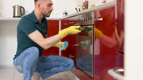 Man with Rag Cleaning Oven Door at Home Kitchen 8