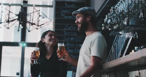 Friends dancing and drinking a beer in a nice modern bar