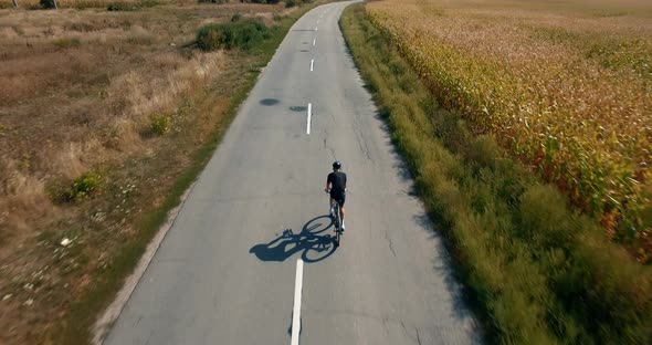 Cycling Exercise From Drone. Aerial Cyclist Triathlete Ride On Rural Road. Aerial Triathlon Cyclist.