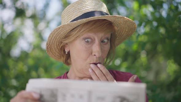 Front View Thoughtful Embarrassed Caucasian Senior Woman Solving Crossword Puzzle in Slow Motion