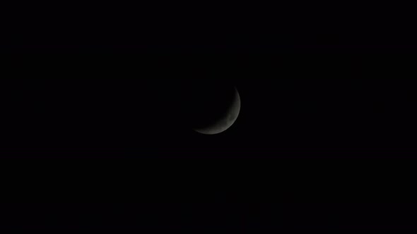 The moon in the dark sky in it's waxing crescent phase