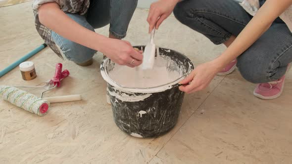 Female House Painters Paint the Walls in the Room.