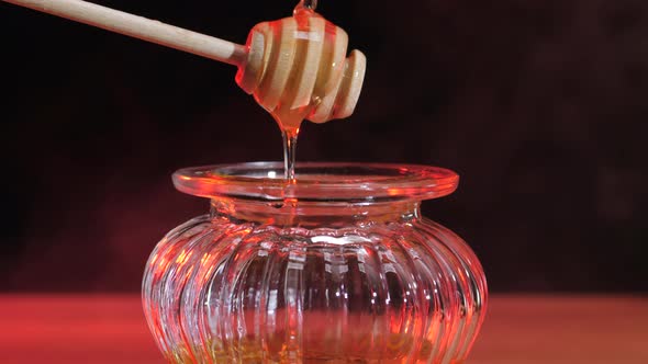 Liquid fresh honey. Golden Honey dripping, pouring from wooden spoon.