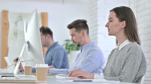 Attractive Creative Woman Doing Video Chat on Desktop in Office