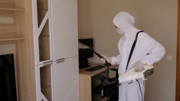 A Man in a Protective Suit Makes Disinfection From the Coronavirus in Apartment