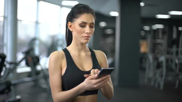 Purposeful Lady in Sportswear Scrolling Smartphone Application, Motivation