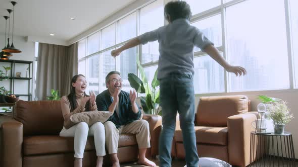 Happiness cheerful asian family dad mom and son funny dancing in living room