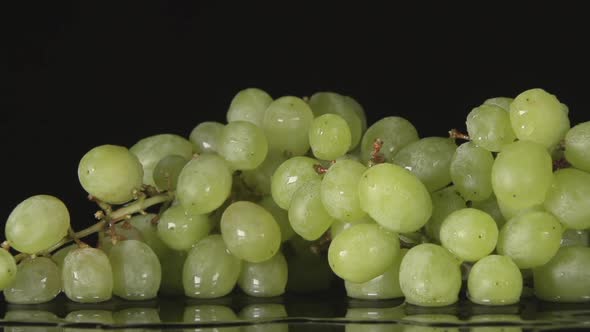 Water Flow Falls On A Bunch Of Grape On A Black Background