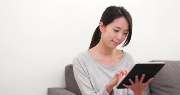 Woman watching on digital tablet computer at home