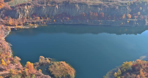 An Quarry Pond Formed During Mining Stone with Overgrown with Green Plants with Clear Turquoise