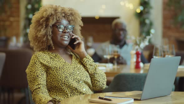African American Businesswoman Chatting on Phone in Cafe