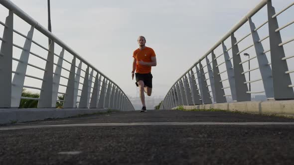 Sporty Caucasian man training on a bridge