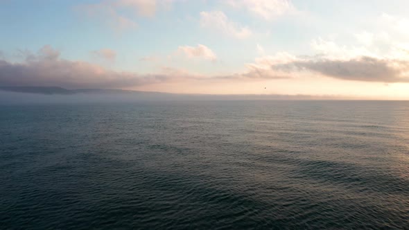 Low clouds over a sea coastline at sunrise