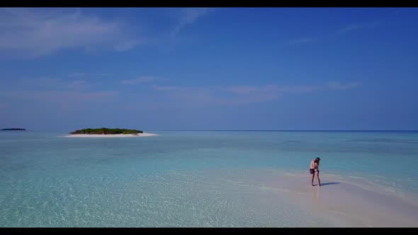 Man and lady tan on beautiful seashore beach break by blue ocean and white sandy background of the M