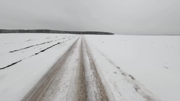 FPV drone view of winter snow-covered dirt road 2