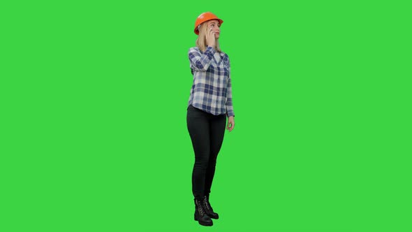 Beautiful Female Engineer in Hardhat Havin a Phone Call Correcting the Project on a Green Screen