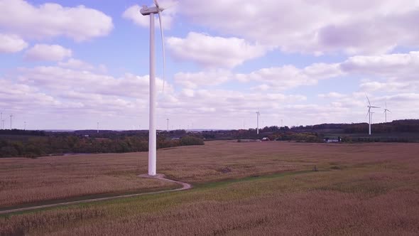 Aerial view of wind turbine creating green and renewable energy.  Camera view is rising in elevation