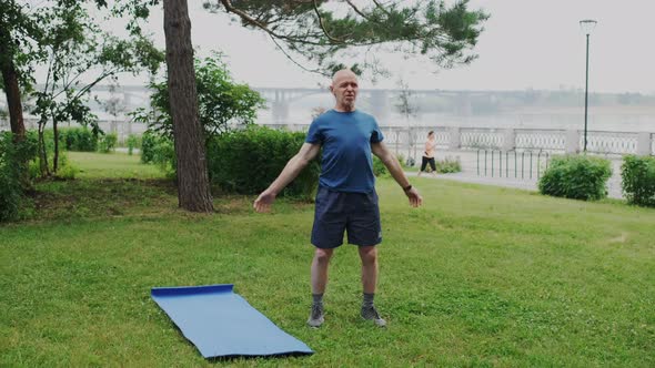 Strong and Healthy Pensioner Performs Gymnastic Exercise in Park Outside