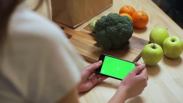  Woman's Hand Browsing Smartphone with Chroma Key on