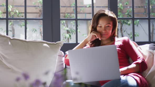 Mixed race woman using a laptop. Social distancing and self isolation in quarantine