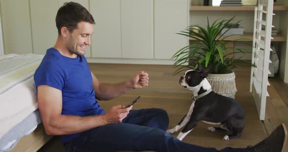 Caucasian man is playing with his dog at home