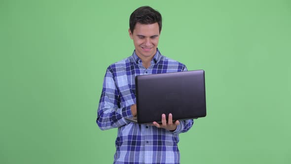 Happy Young Handsome Hipster Man Using Laptop