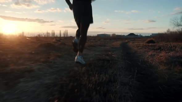 Running Man In Uphill At Sunset.Runner Man Fit Athlete Legs Jogging On Trail Ready To Triathlon.