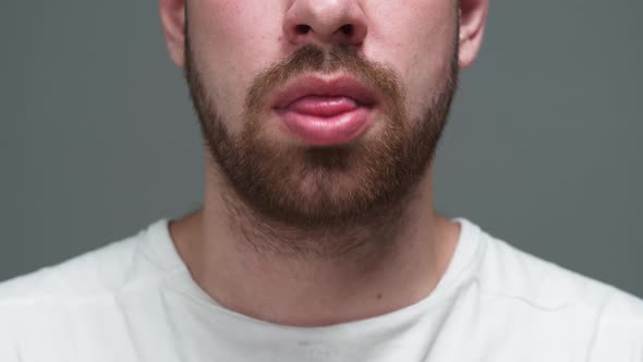 Man with Beard Opening Mouth and Putting Medication Pill on His Tongue Closeup