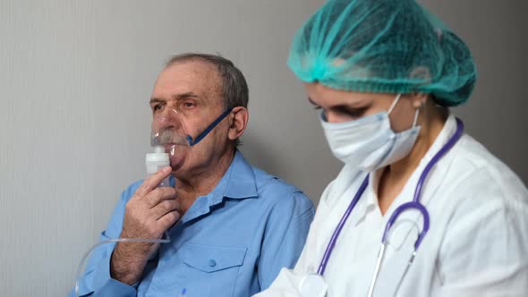 Old Man Does Inhalation While Doctor Writes Notes