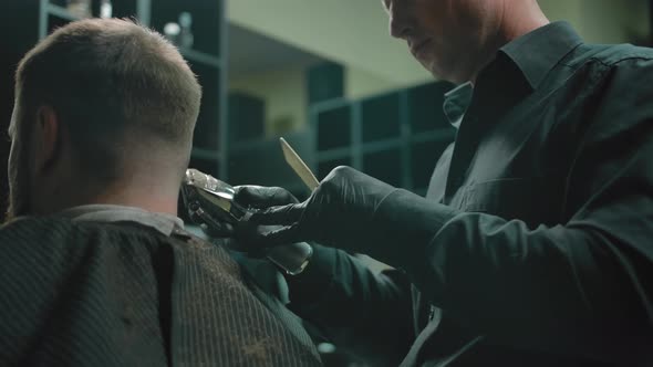 Dark Dimly Lit Artistic Shot with a Trimmer Haircut in a Barbershop